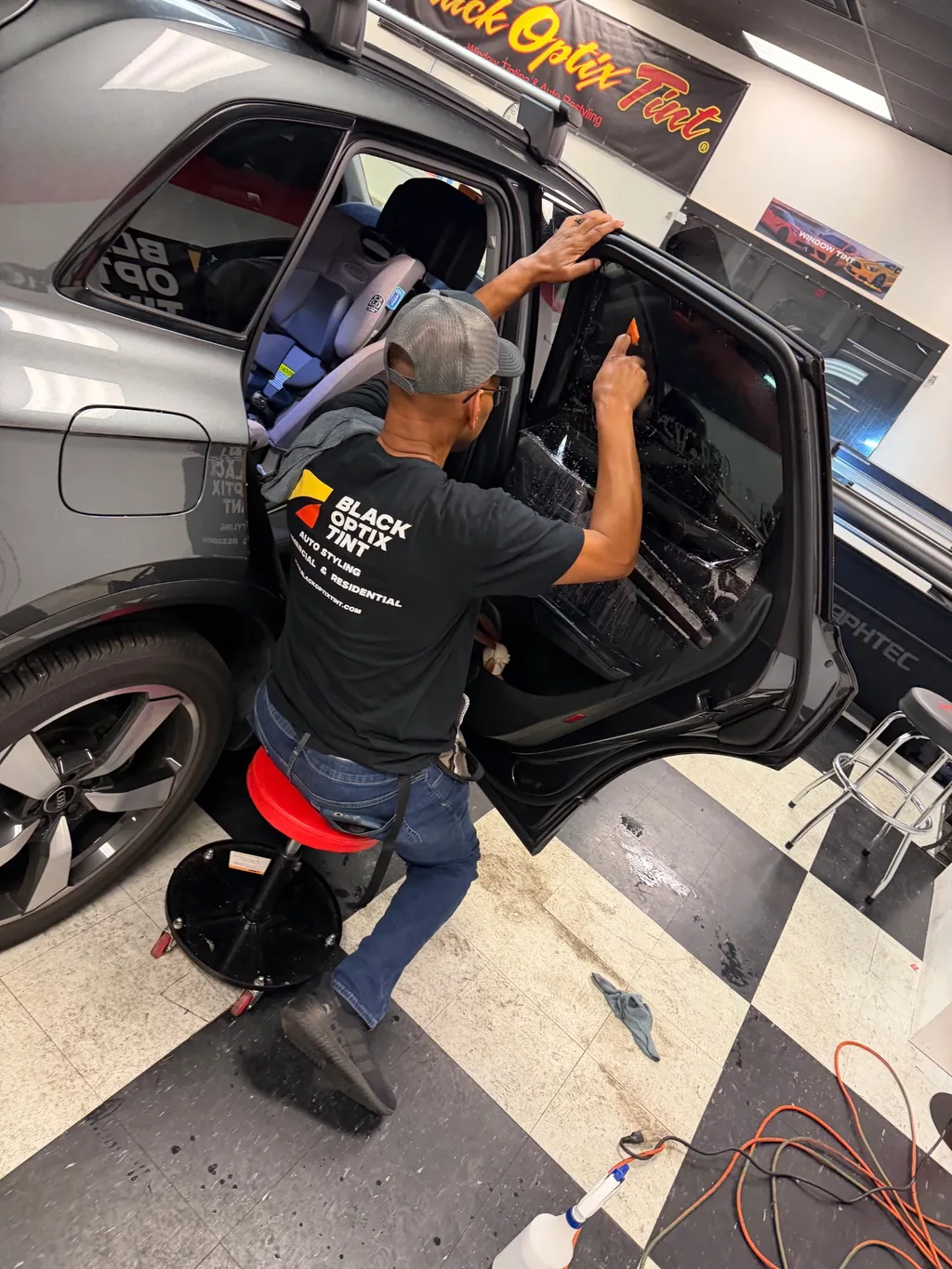Installer laying window film on an Audi SUV at Black Optix Tint Pensacola